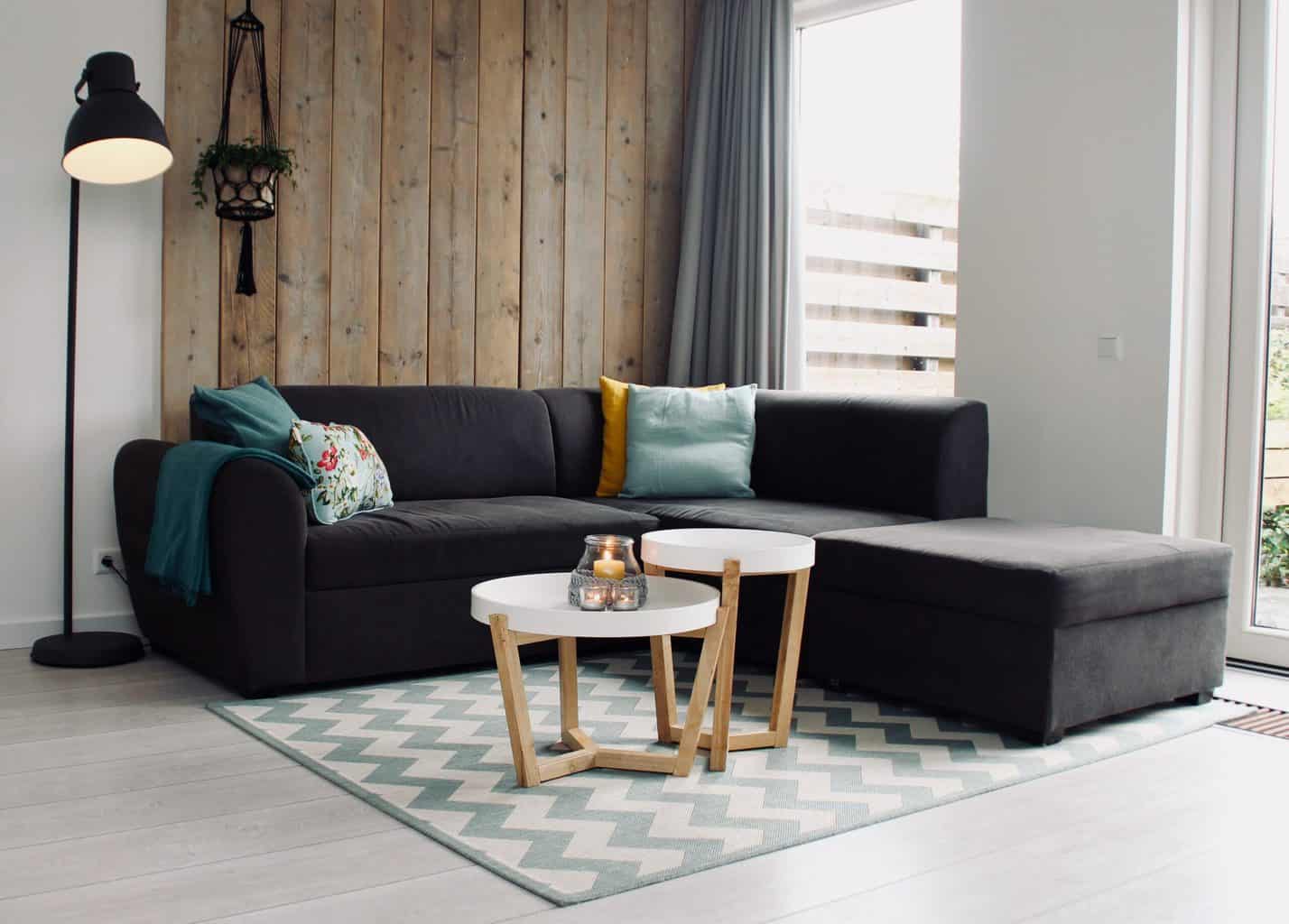 A living room with a black sofa and a floor lamp