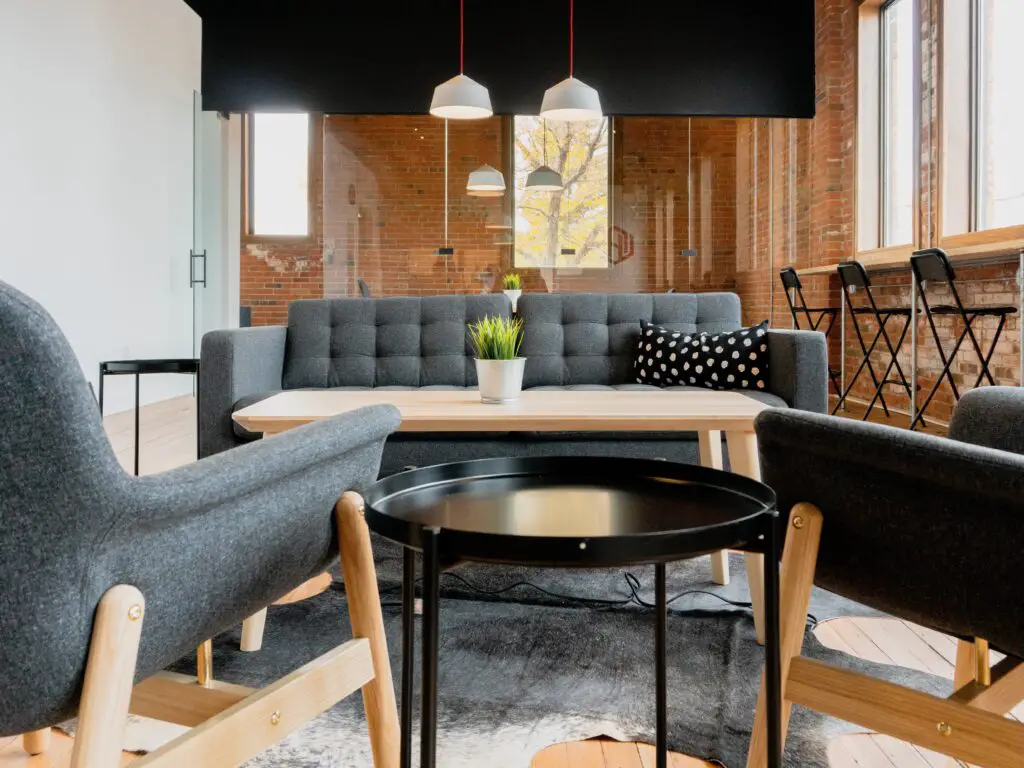 A room with black sofa, table, and chairs