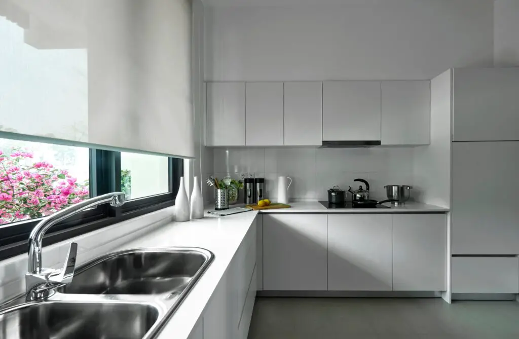 white toned cabinets near window 
