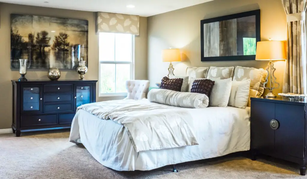 bedroom near the window with a mirror and cabinets