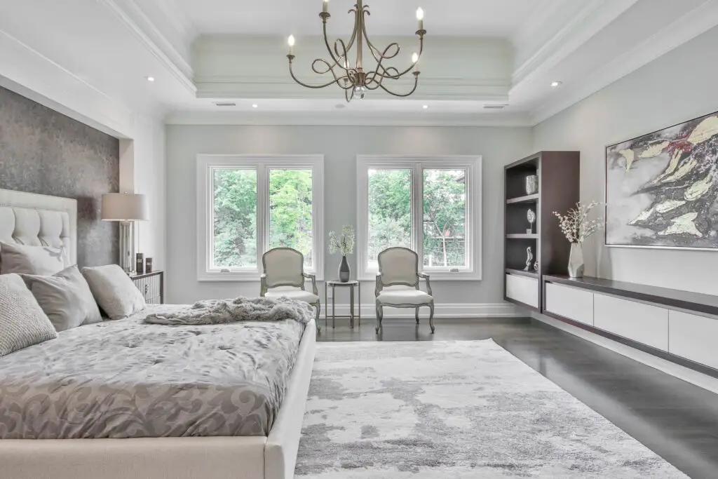 a white and gray toned bedroom with two windows