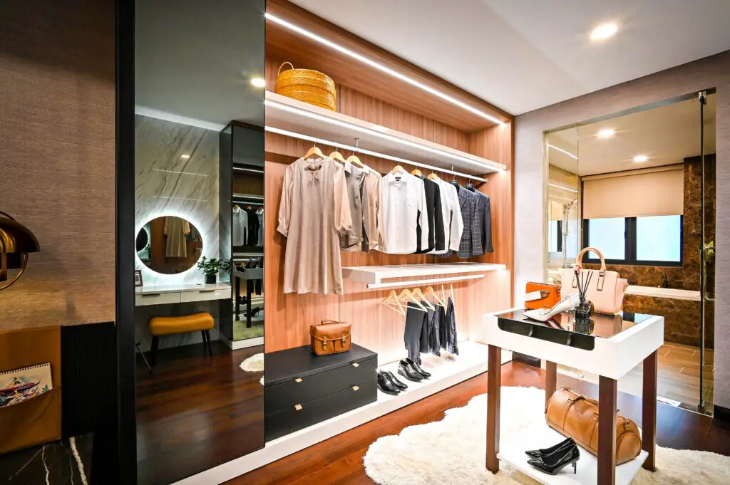 An open closet with mirror and clothes