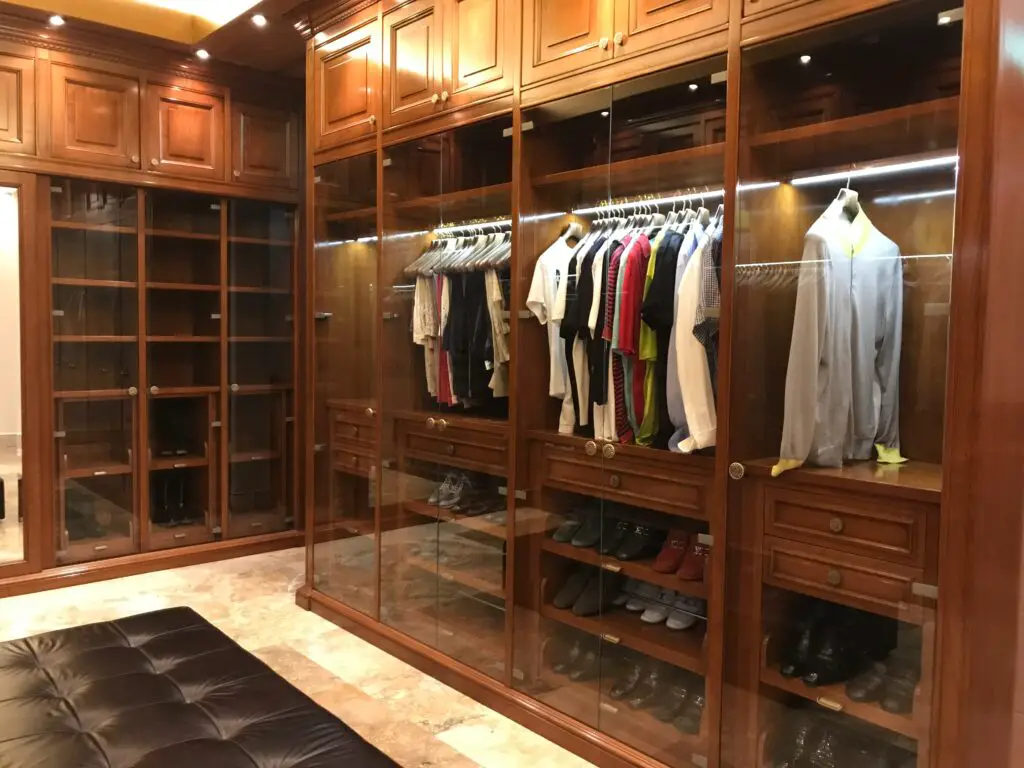 A mirrored closet with clothes and shoes