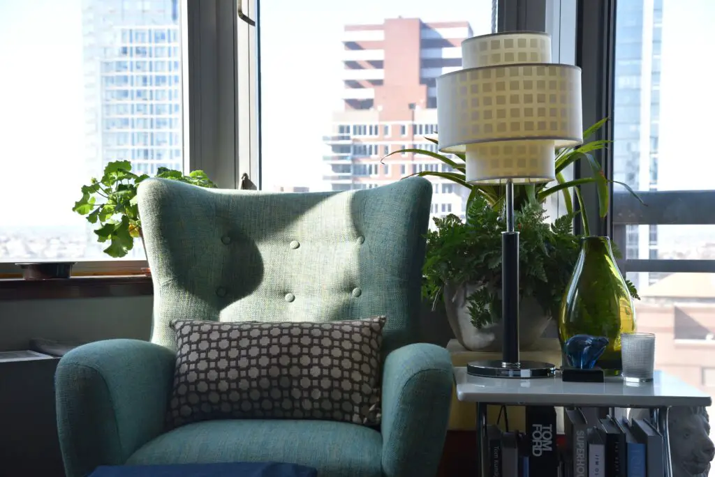 A chair with a lamp near the window