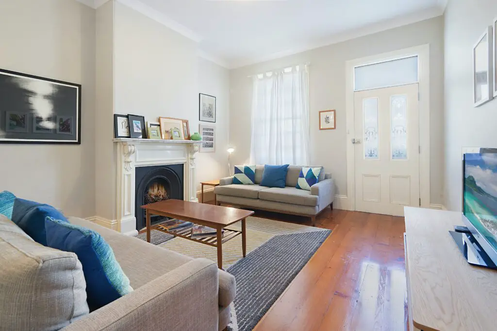 A white toned living room with sofas and blue pillows