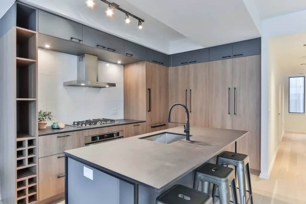 A faucet in the kitchen area with chairs