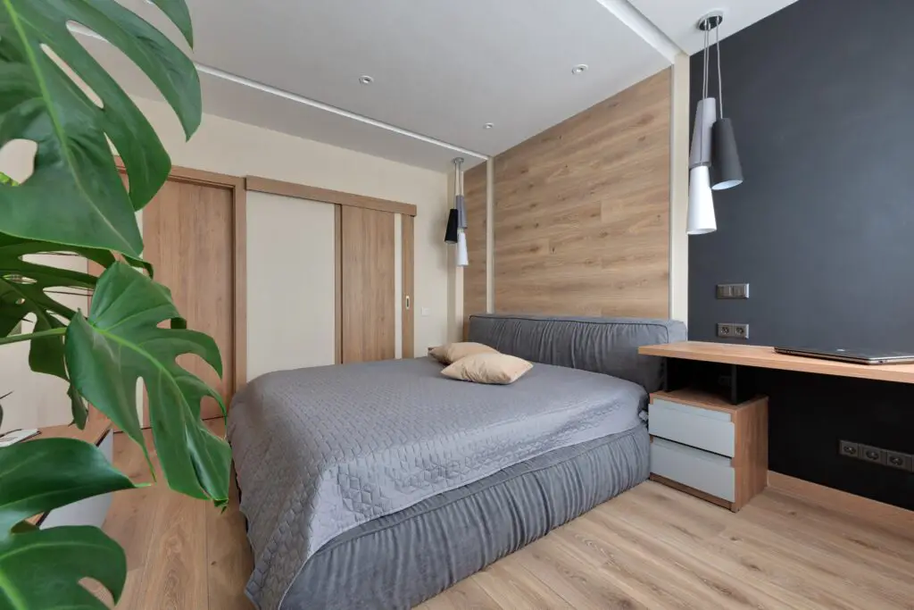 A bedroom with a gray bed