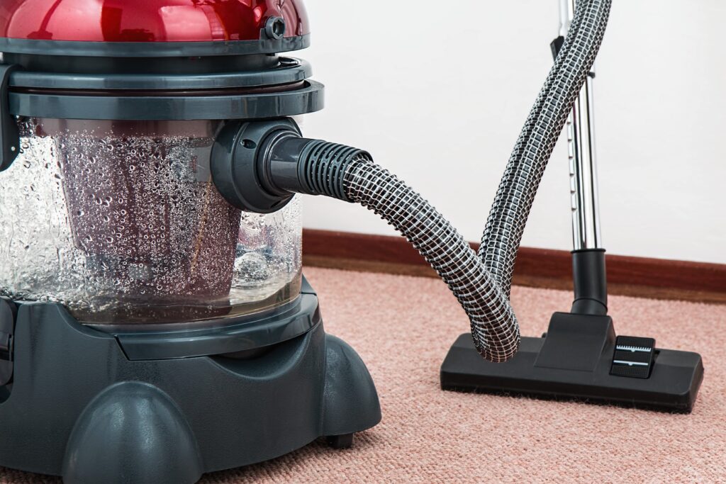 Red vacuum cleaner on carpet