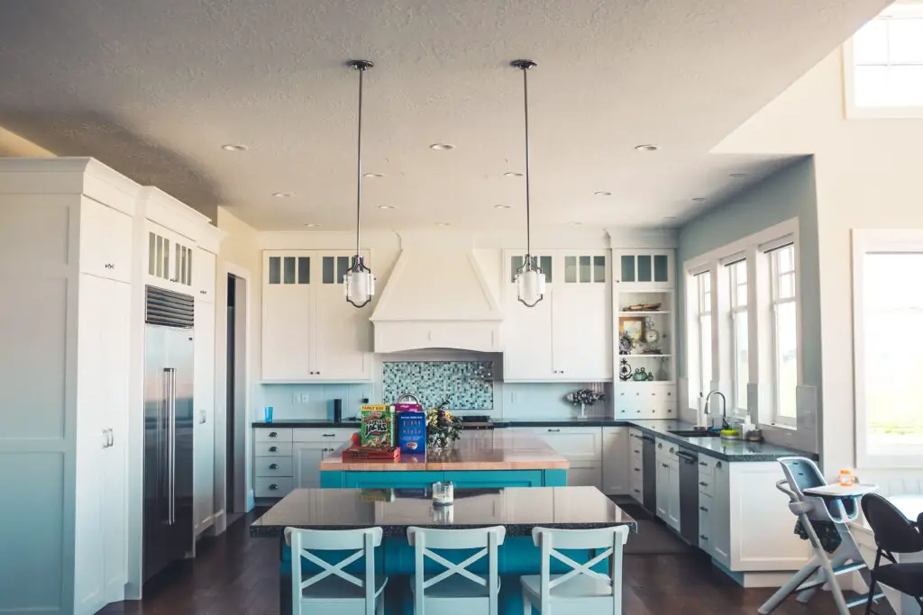 A kitchen area with windows and cabinets 