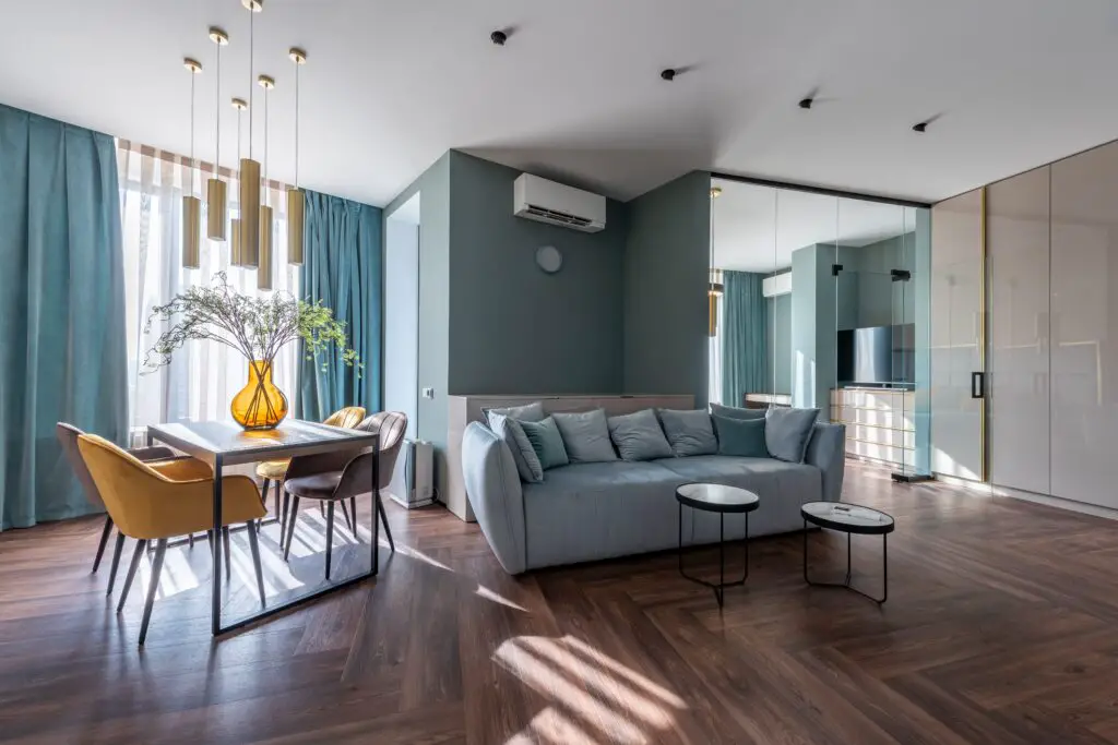 A blue green toned living room with sunlight