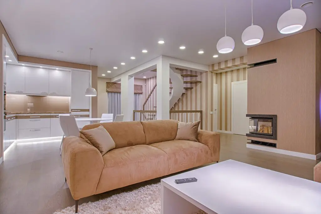 A big brown sofa in the living room with lights