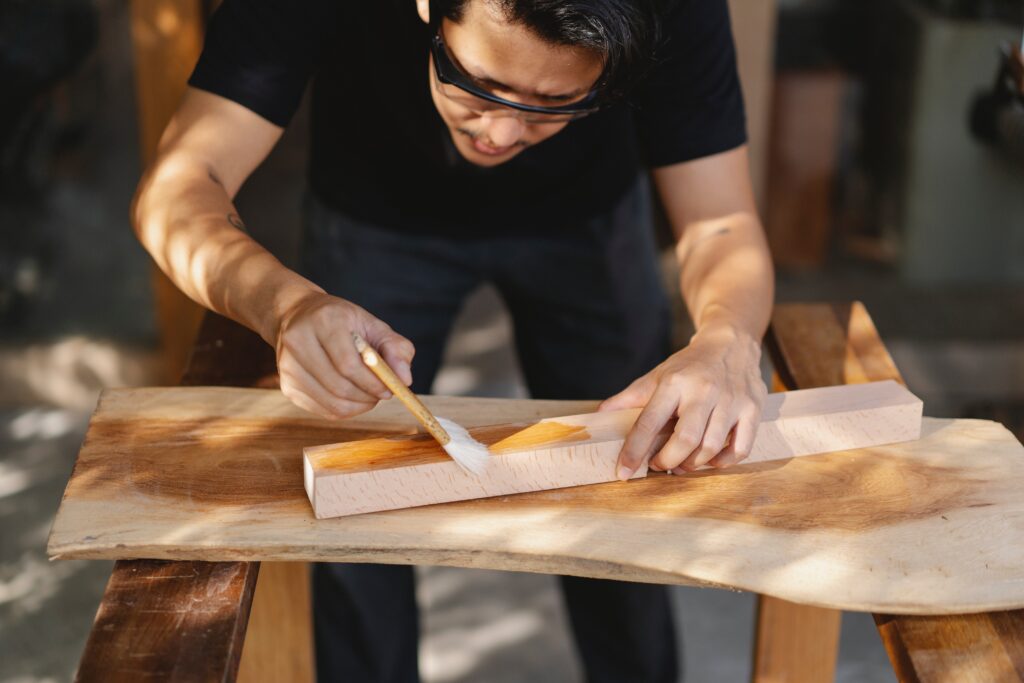 A man applying varnish to a wood