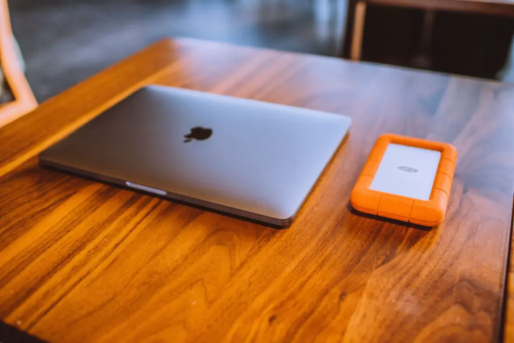 A shiny wooden table with a laptop