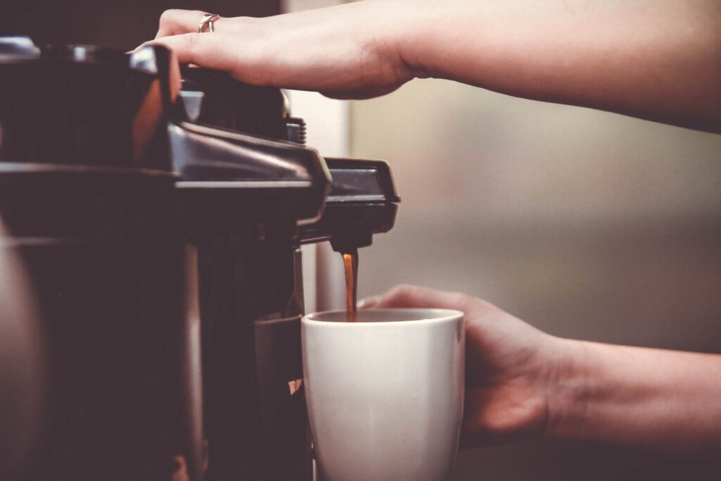 A coffee maker pouring coffee to a mug