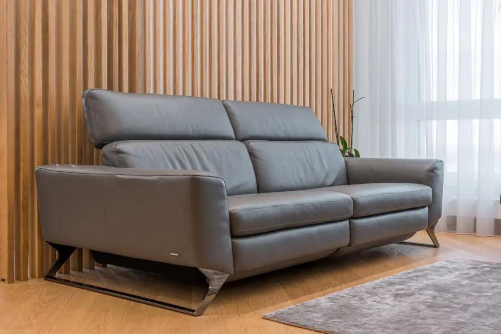 A gray leather couch on hardwood floor