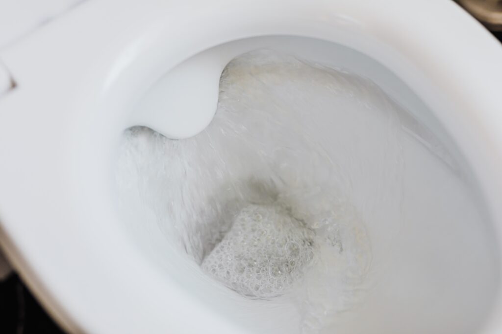 Flushing water in white toilet bowl
