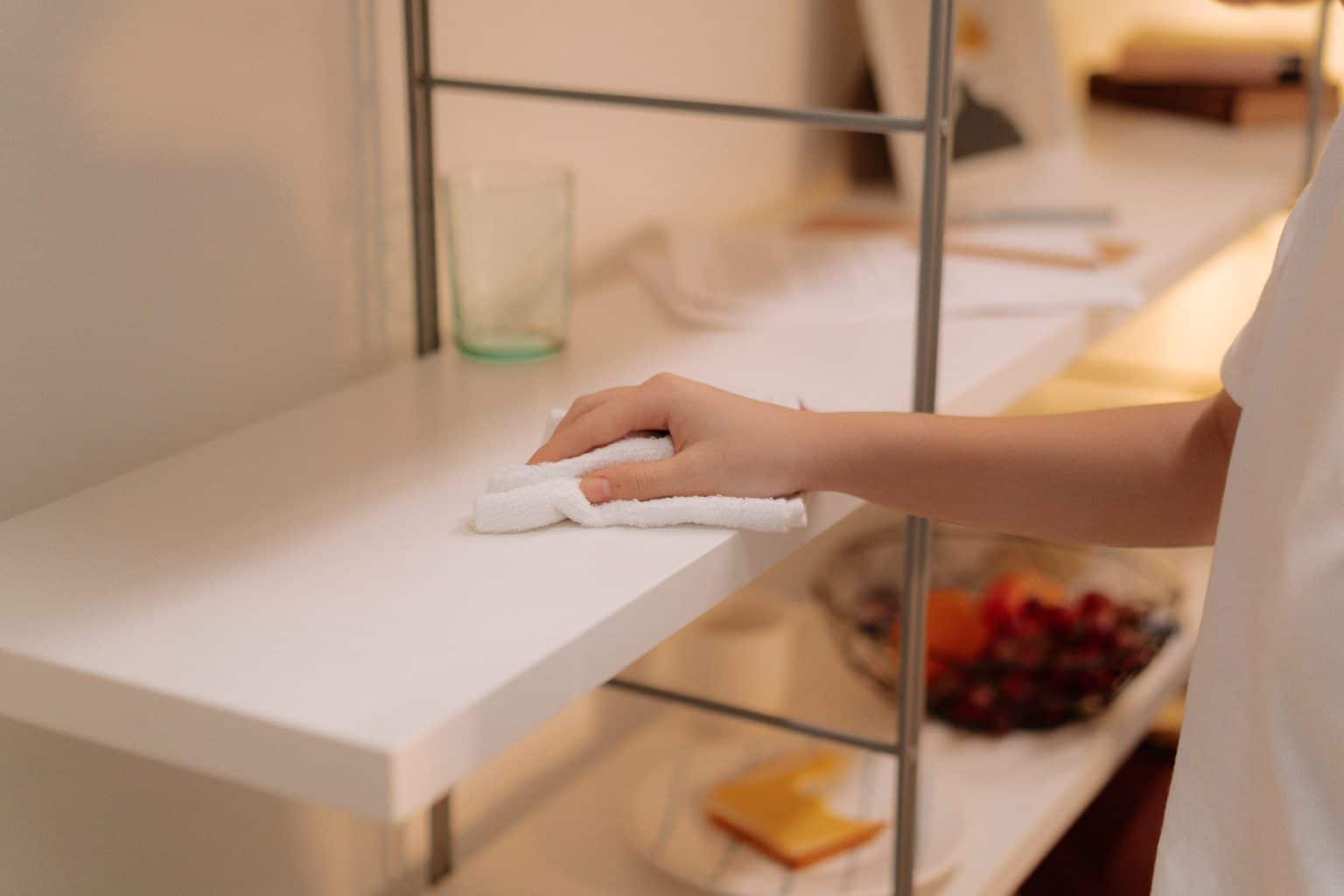 Wiping a white wood compartment with a cloth