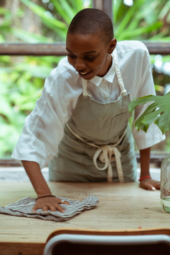 A waitress wiping a wooden table
