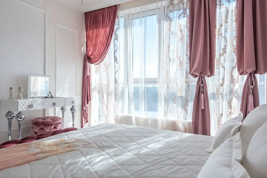 Room with white bed and white curtains