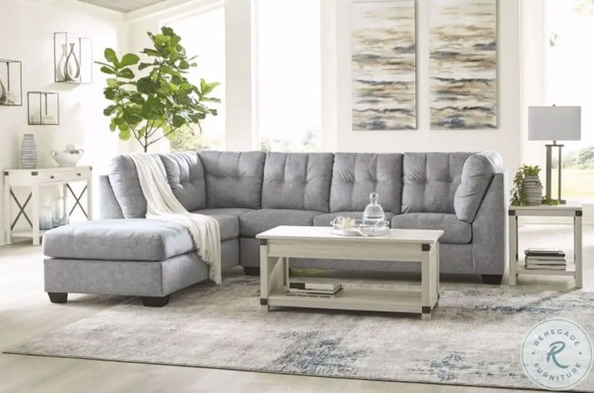 Gray sectional sofa with a white cloth draped on its edge and a white painted coffee table placed on the middle