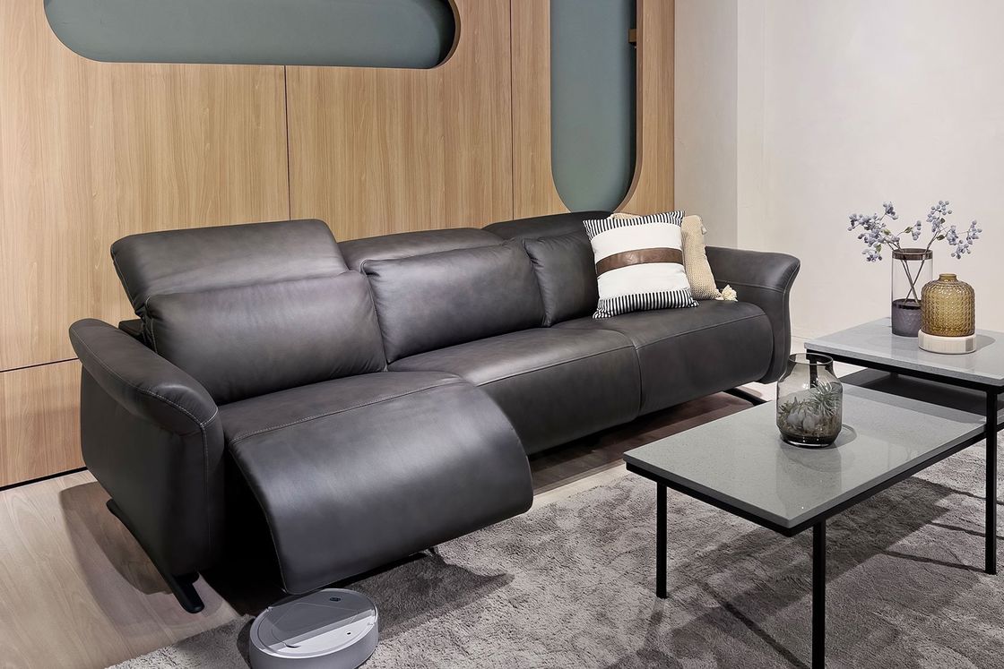 Black sectional leather sofa with a gray center table