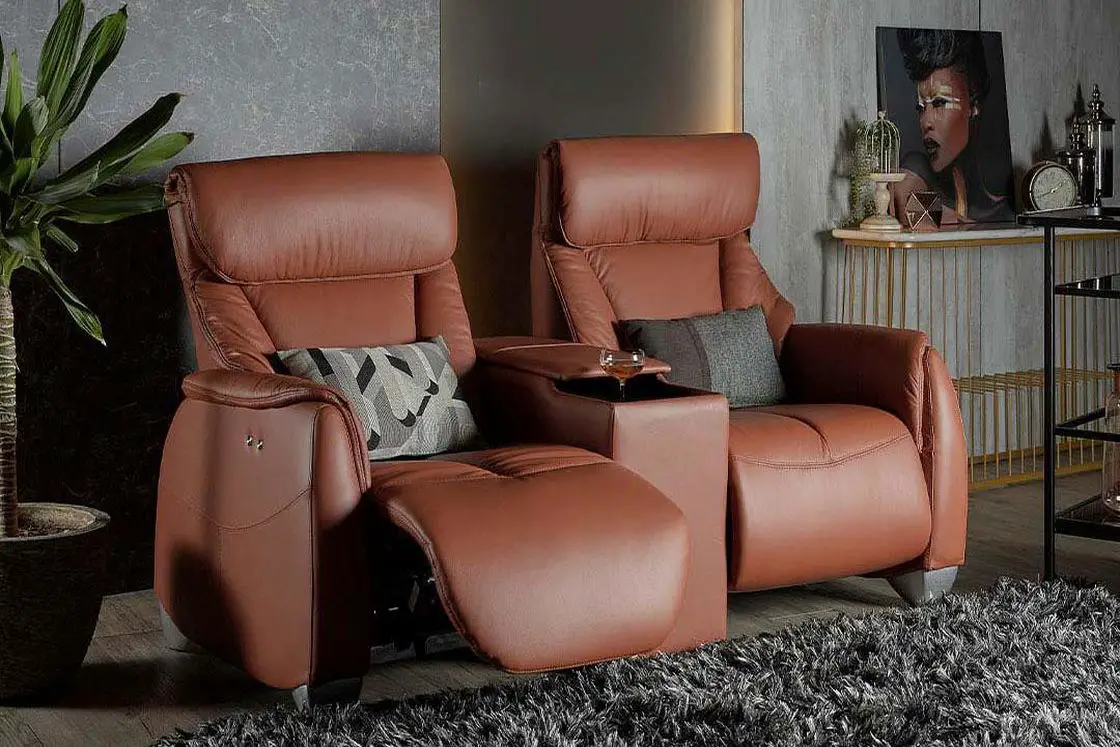 A pair of brown leather recliner chairs with a gray rug