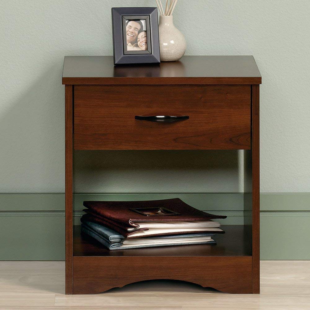 A brown bedroom side table with a picture frame and case on top