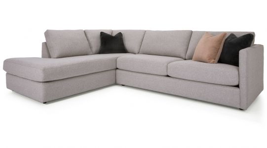 A gray sectional sofa with two black throw pillows and one brown throw pillow
