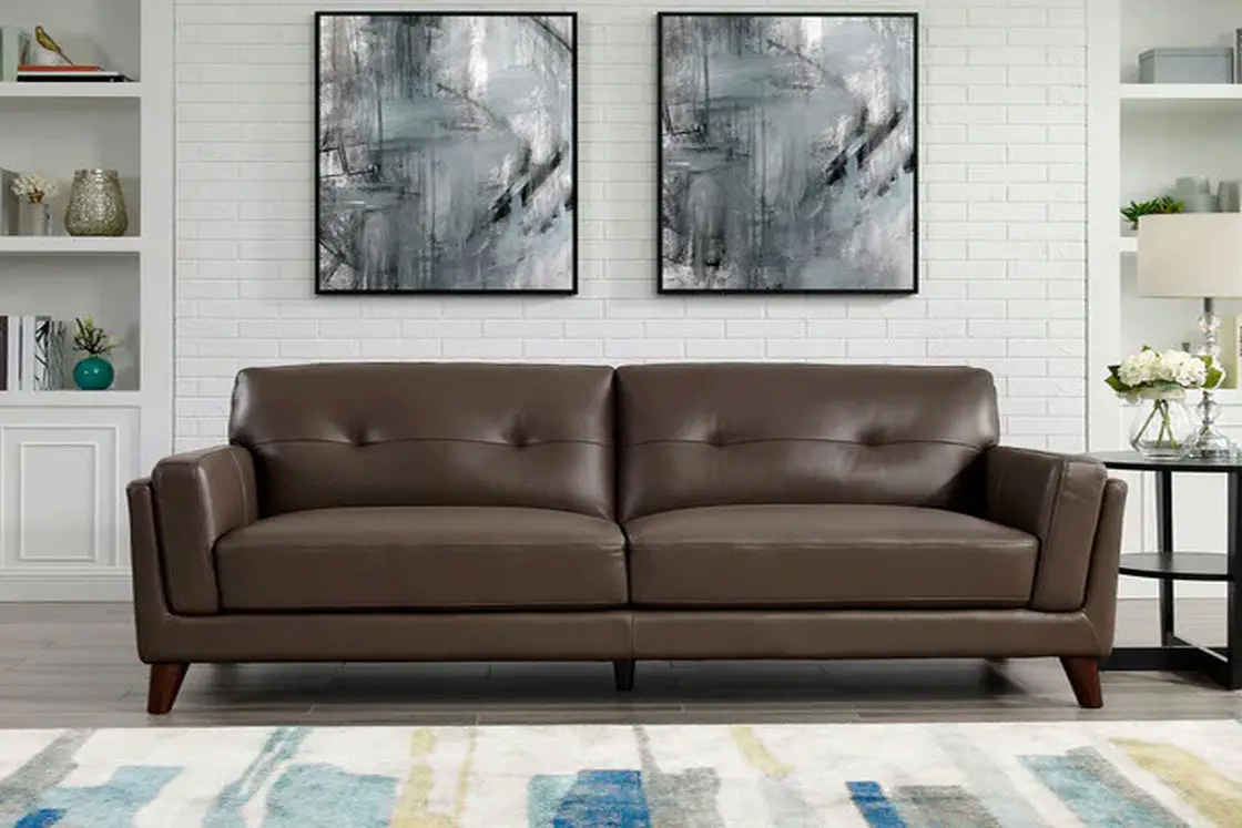 A brown leather sofa beside a black table placed on a gray flooring